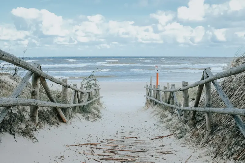 Strandzugang mit Holzzaun zwischen den Dünen